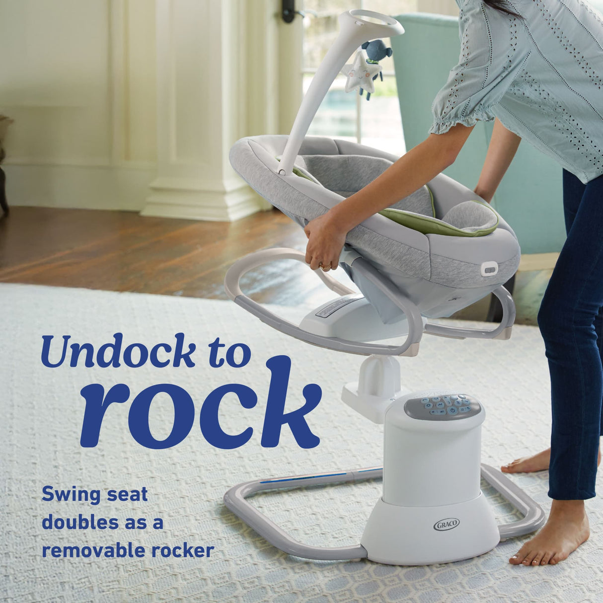 Baby swing seat with text 'Undock to rock' on a light-colored floor.