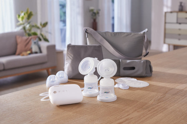 Breast pumps and accessories on a wooden table with a blurred background