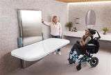 Person in a wheelchair interacting with a modern bathroom setup.