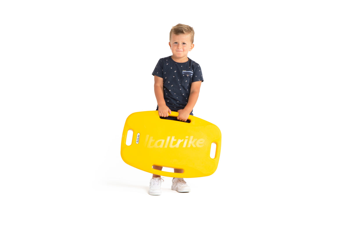 Child holding a yellow italtrike board on a white background