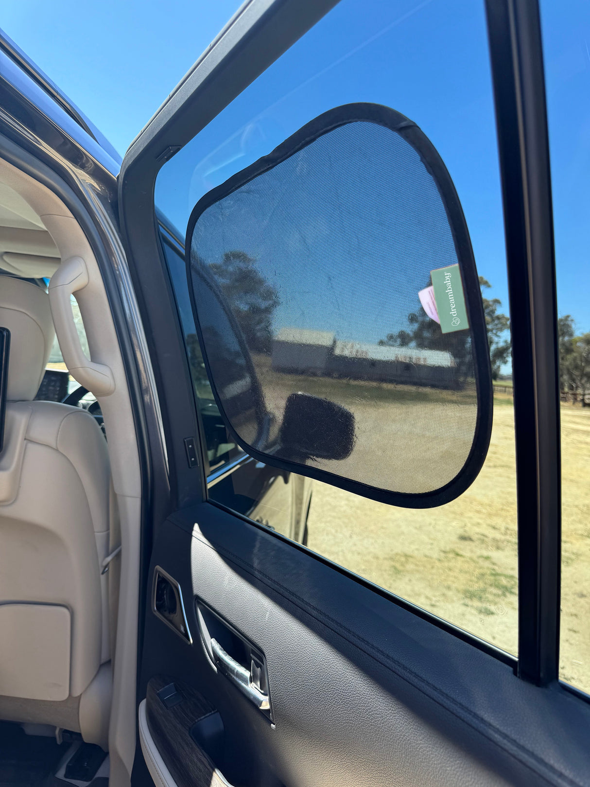 Car door open with car shade with a clear sky landscape.