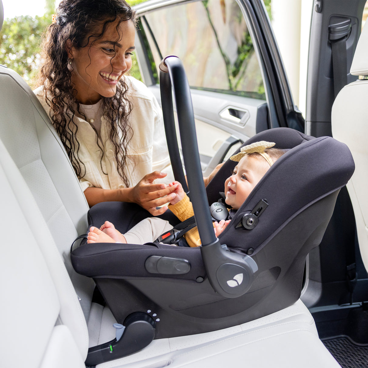 Woman adjusting a car seat for a baby inside a vehicle