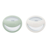 Two round containers with lids, one green and one white, on a white background.