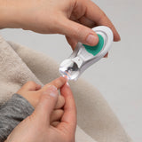 a mother using baby nail clippers to clip a baby's nails