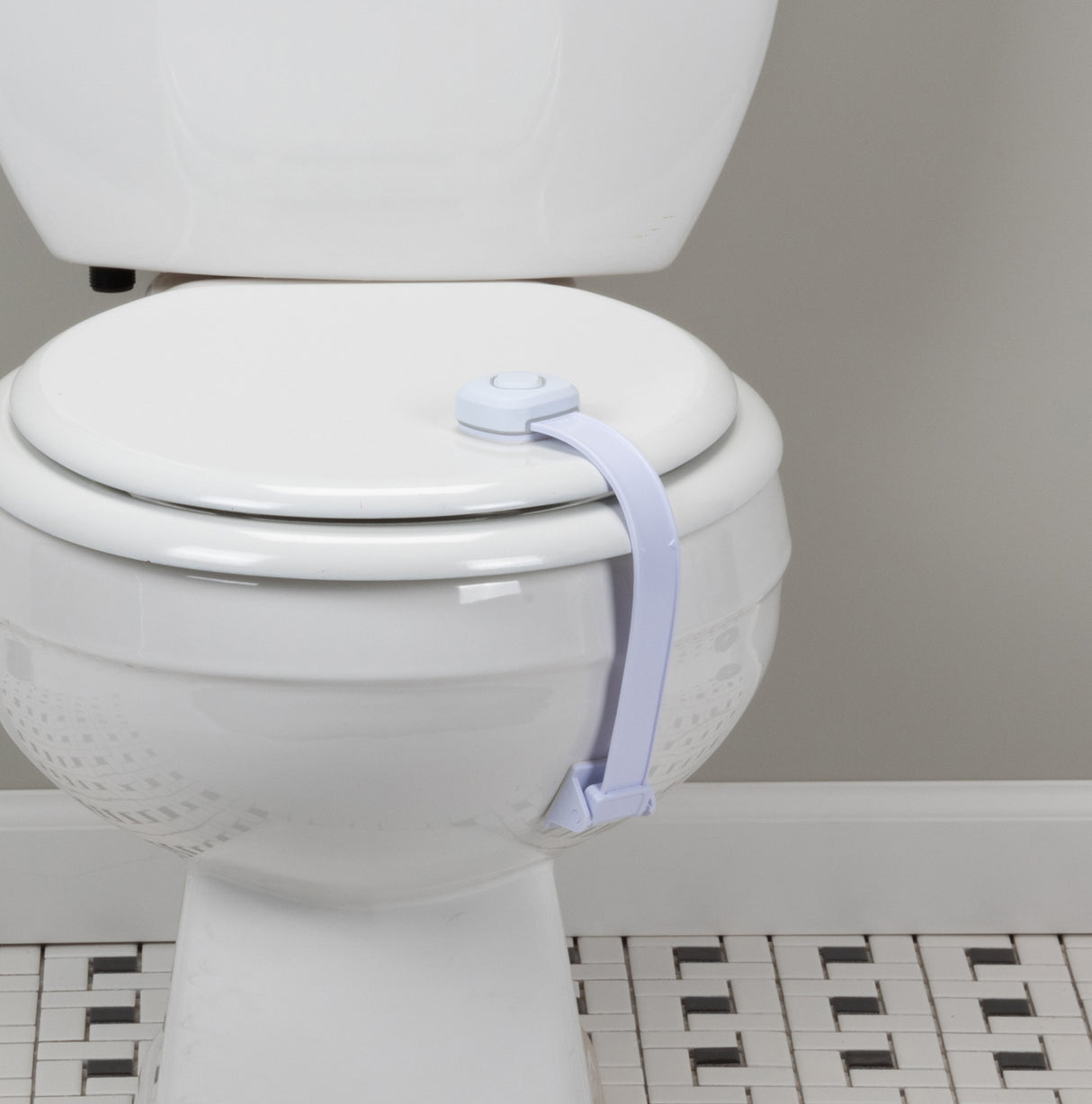 White toilet with a white strap around the seat in a bathroom setting